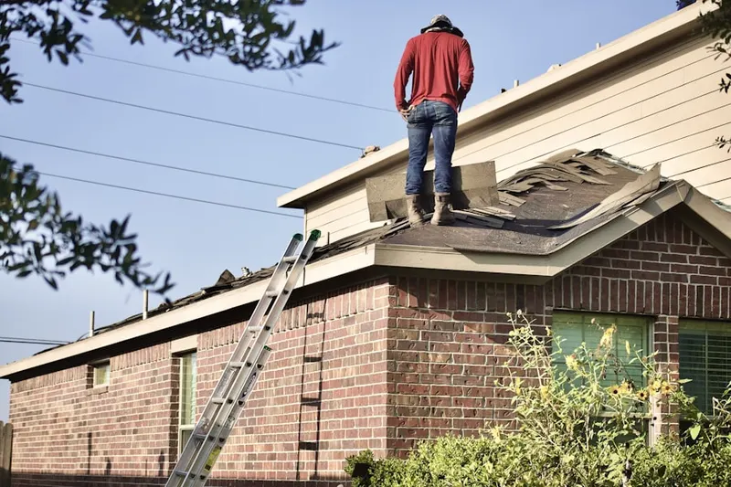 Professional roofer working on a residential roof in Medith Manor
